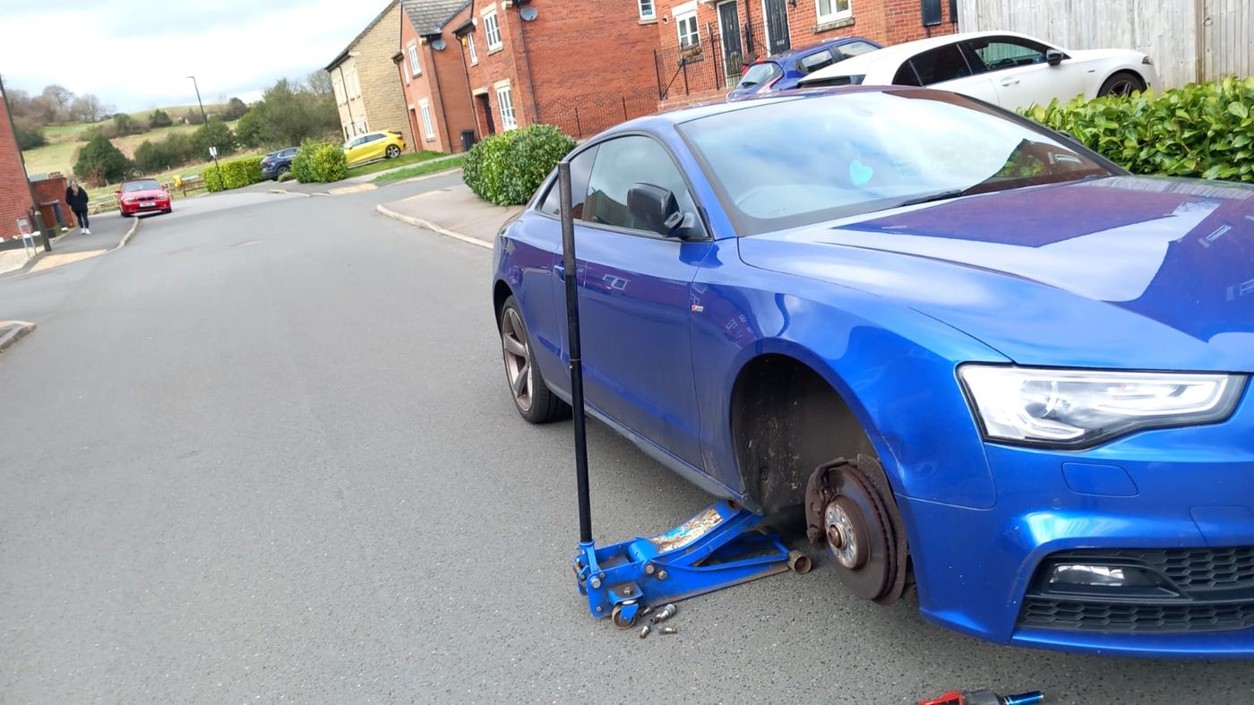 Mobile tyre fitting in progress on a car at the roadside